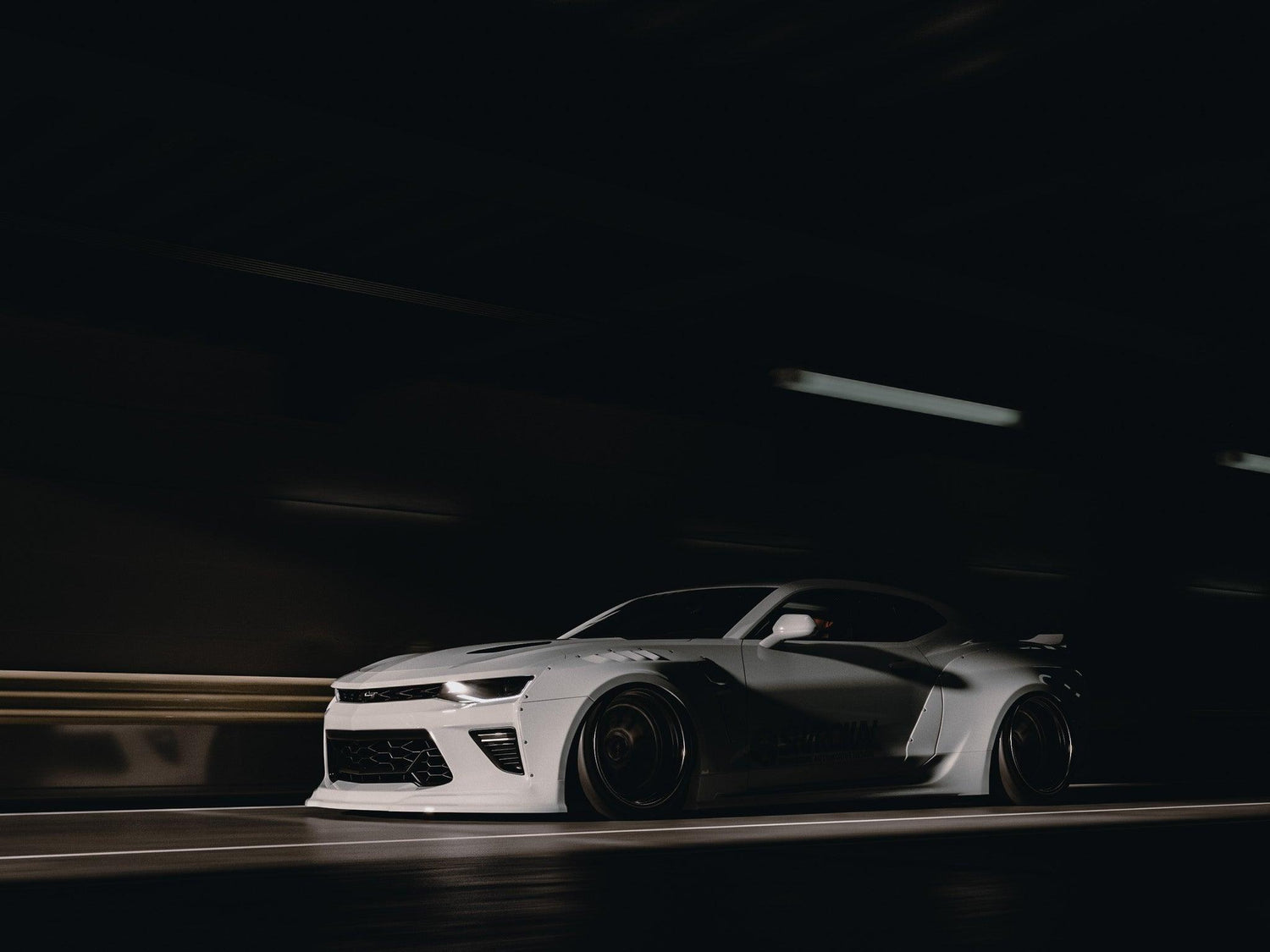 Chevrolet Camaro 6th gen widebody kit SHIROKAI Stance lowered Chevy in white under low light