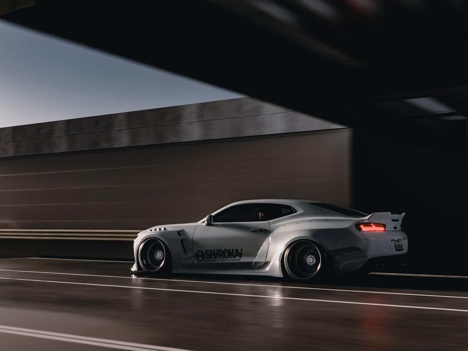 Chevrolet Camaro 6th gen widebody kit SHIROKAI Stance lowered Chevy in silver color driving on street at dusk