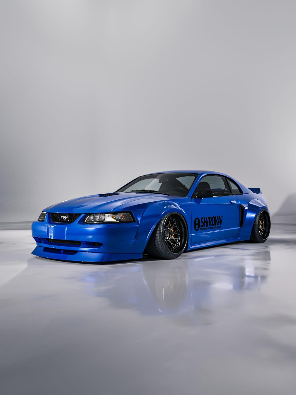 Blue 1999-2004 Mustang SN95 Cobra wide-body kit by SHIROKAI on a sleek custom Mustang