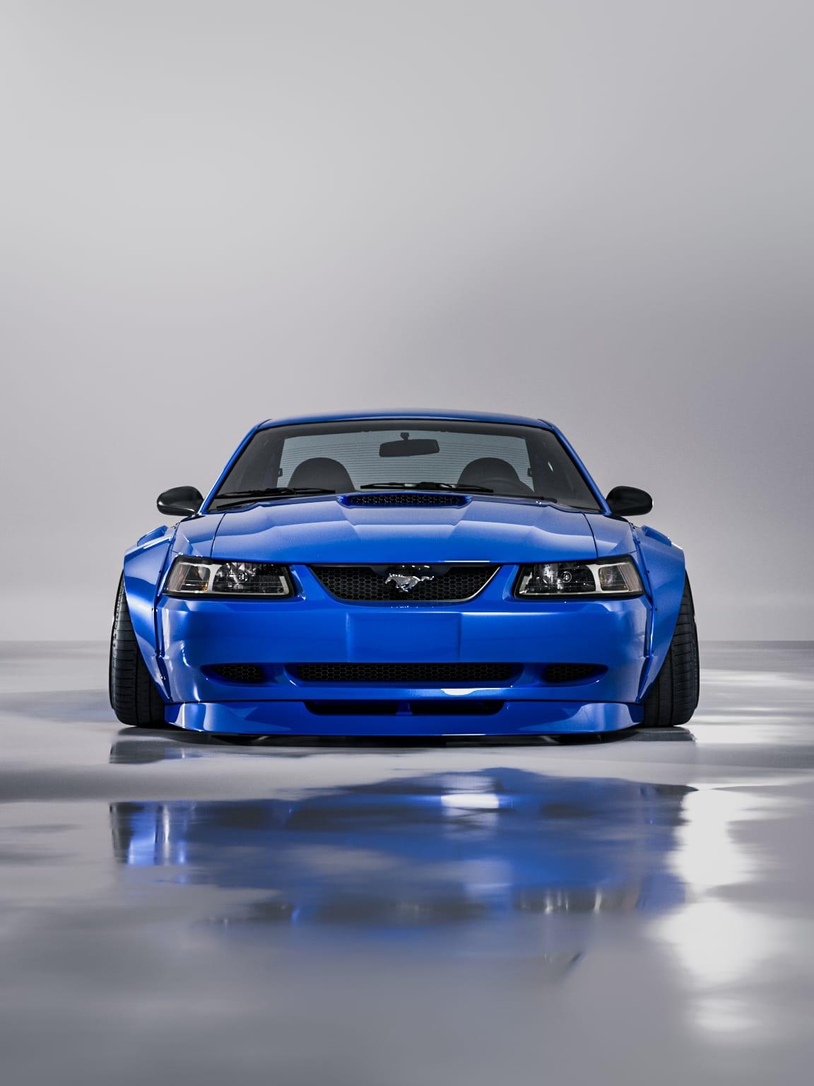 Blue 1999-2004 Mustang SN95 Cobra wide-body kit by SHIROKAI on a Mustang car front view