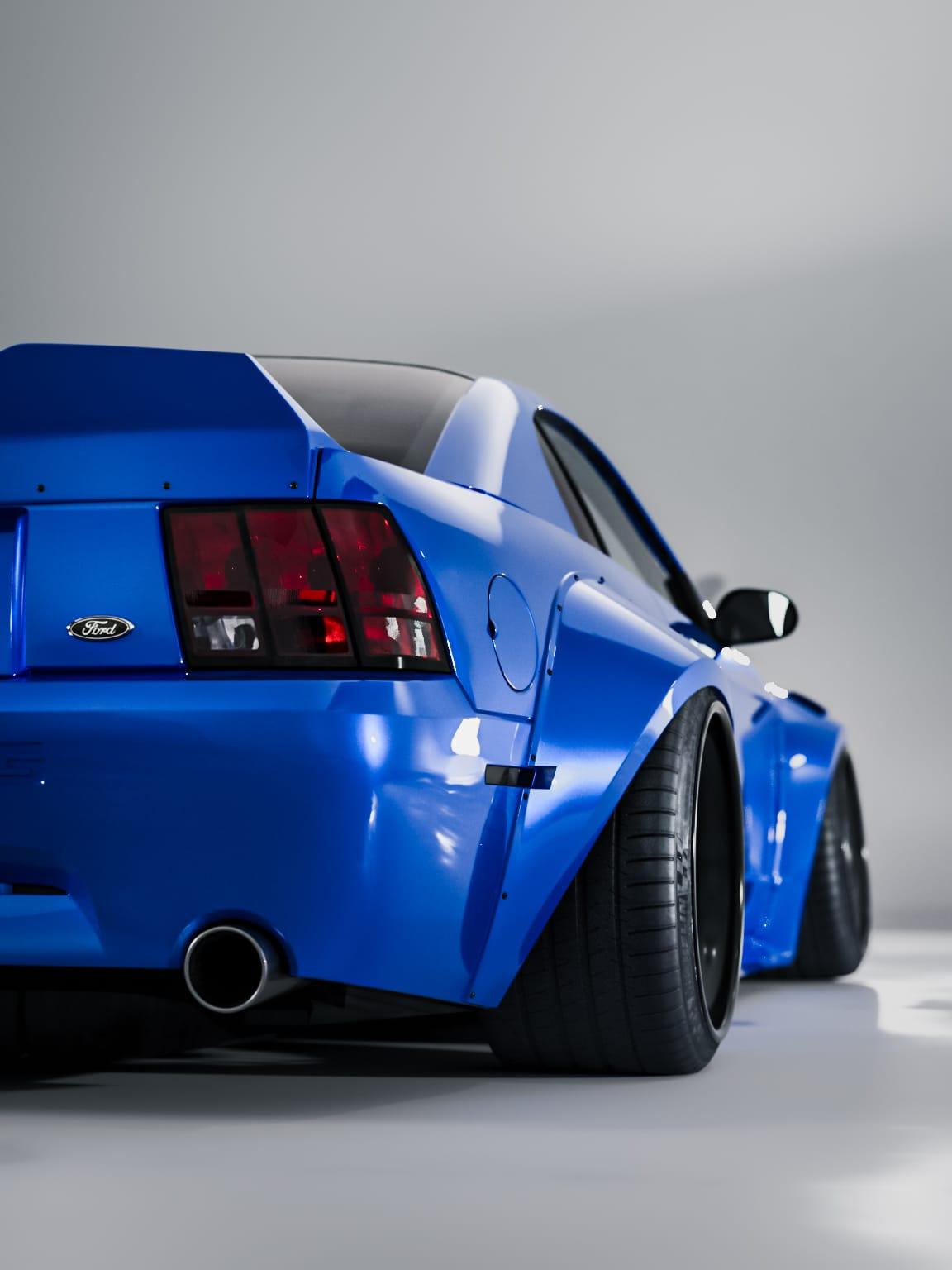 Blue 1999-2004 Mustang SN95 Cobra wide-body kit by SHIROKAI showing rear and side fender details