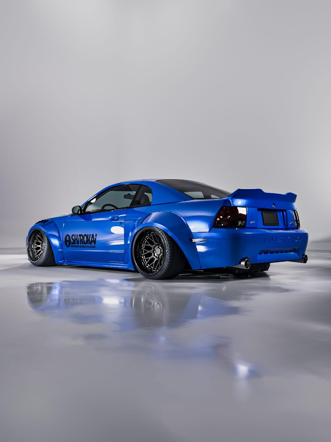 Blue 1999-2004 Mustang SN95 Cobra wide-body kit by SHIROKAI on a lowered Mustang with custom wheels