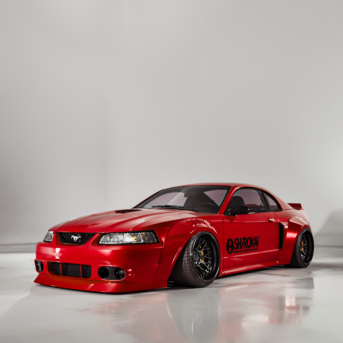 Red 1999-2004 Mustang SN95 Cobra wide-body kit by SHIROKAI on a customized Mustang with aggressive stance