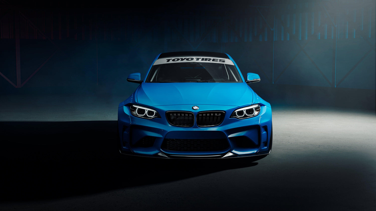 Front view of blue BMW M2 with 2015-2018 widebody kit SHIROKAI installed in dark studio