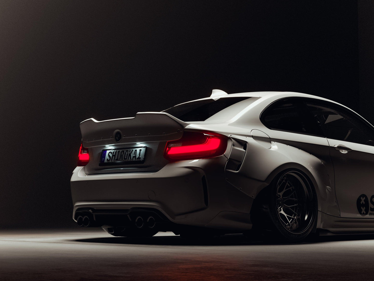 BMW M2 2015-2018 widebody kit SHIROKAI installed on white car rear with aggressive fenders and spoiler