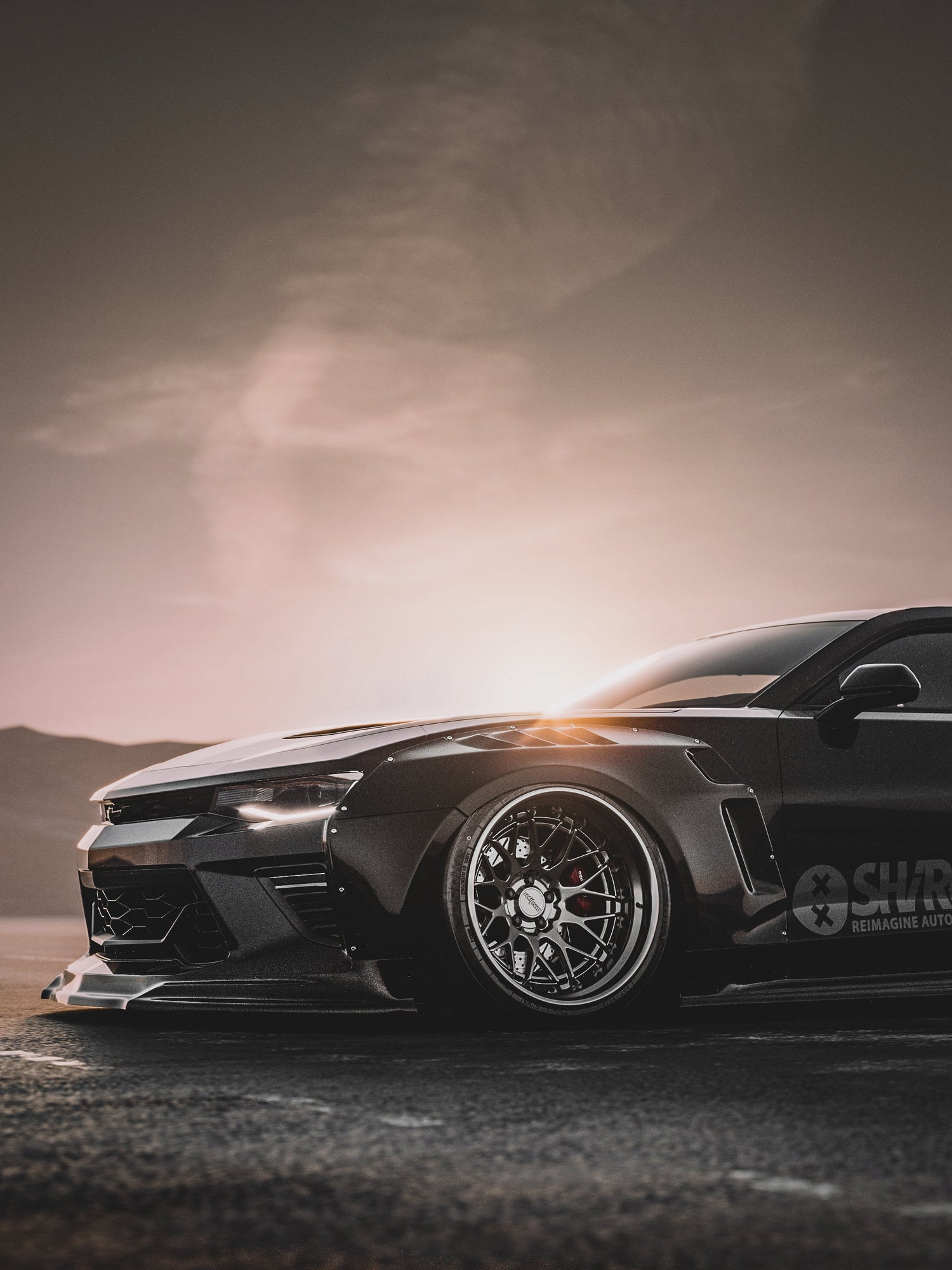 Chevrolet Camaro 6th gen widebody kit SHIROKAI Stance lowered Chevy with custom rims at sunset