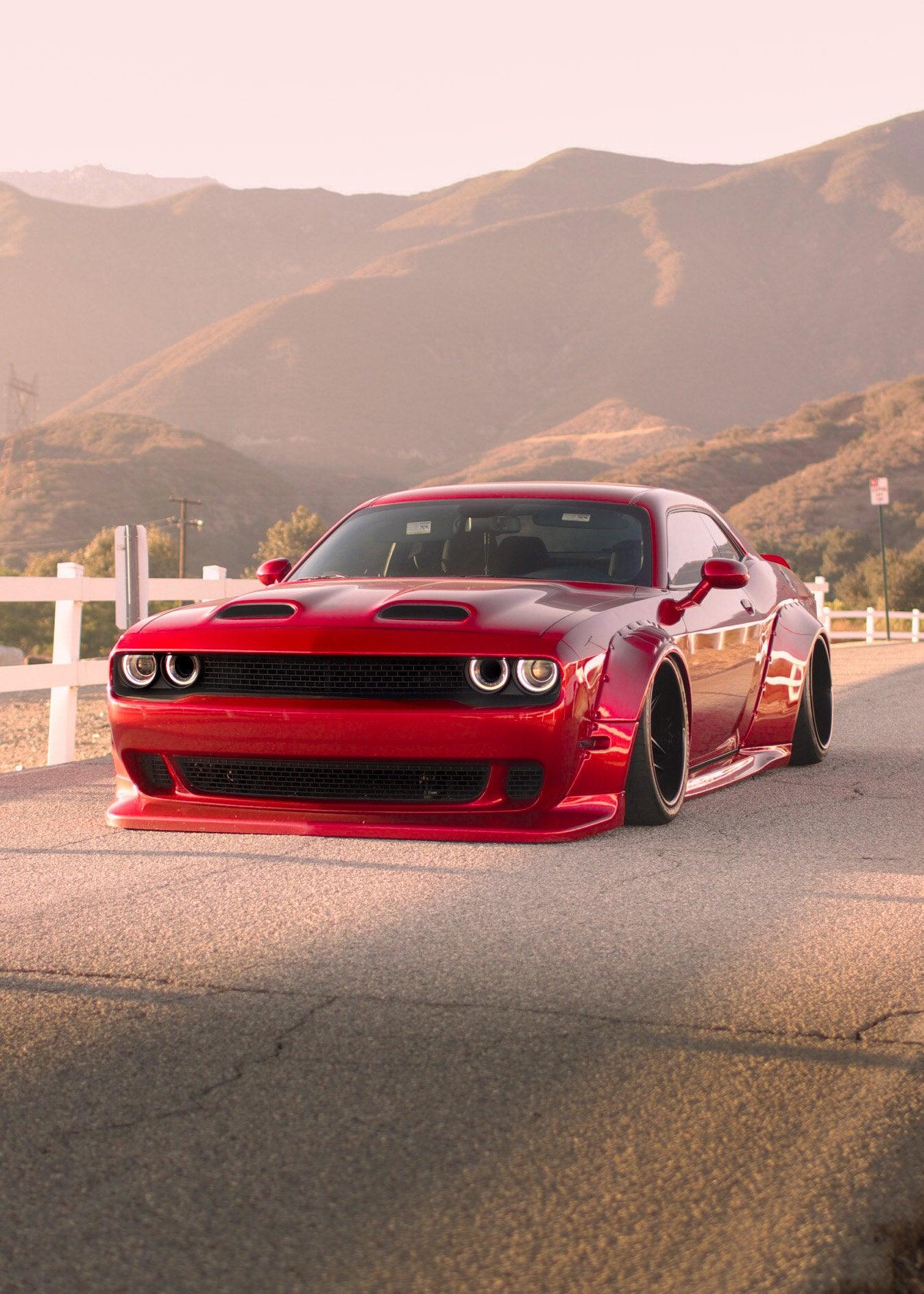 Red Dodge Challenger with HELLCAT SHIROKAI widebody kit parked on a road with mountains in background