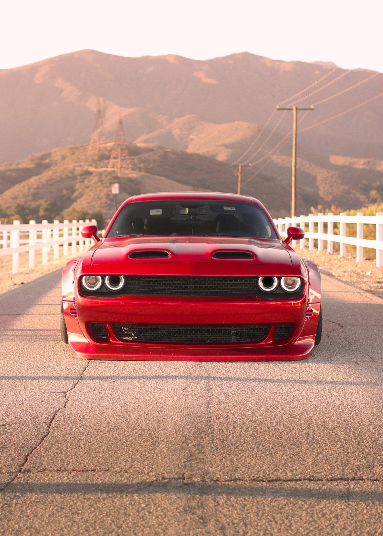 Red Dodge Challenger HELLCAT SHIROKAI widebody kit on a mountain road with white fences