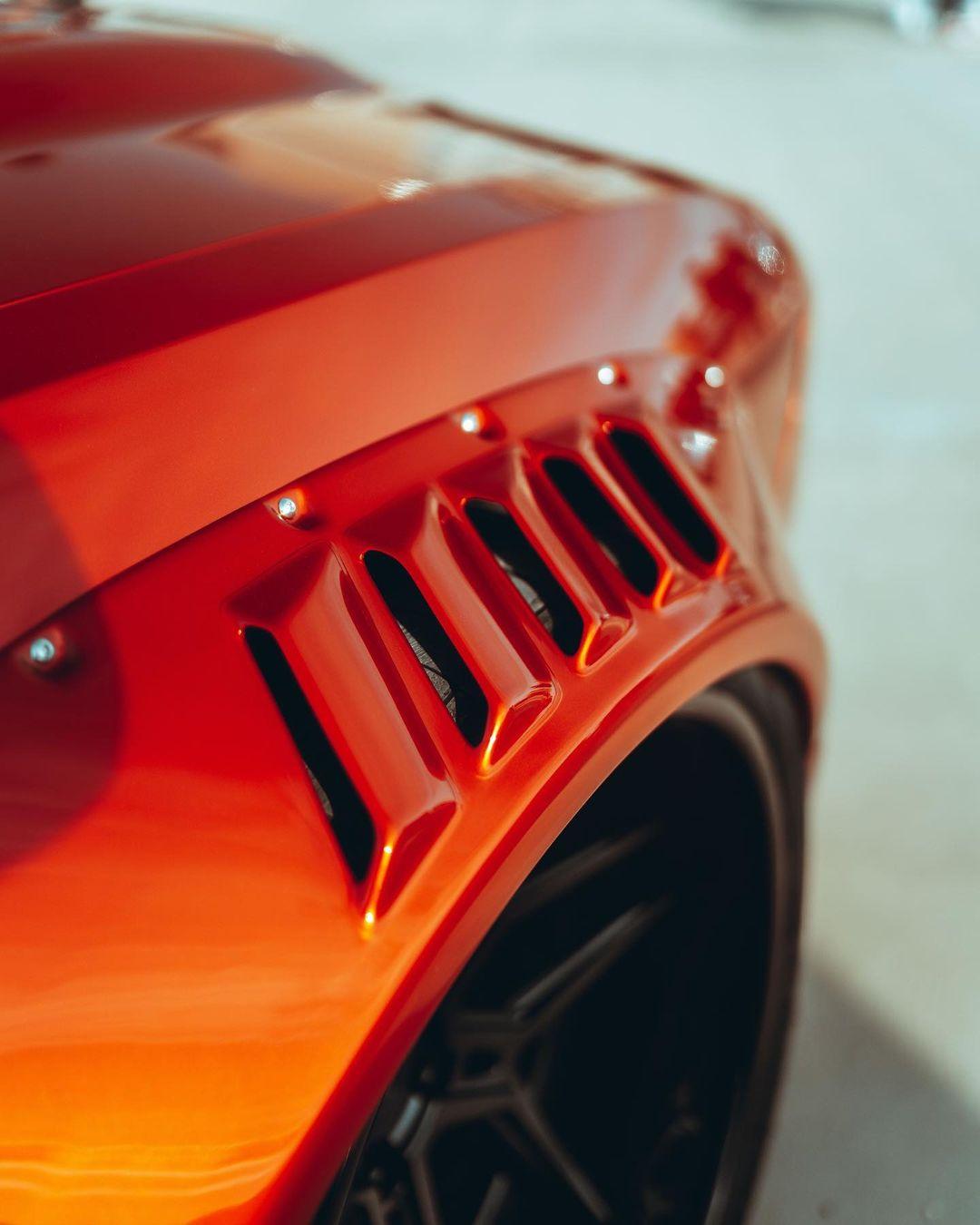 Close-up of Dodge Challenger HELLCAT SHIROKAI widebody kit showcasing red fender vents and rivets