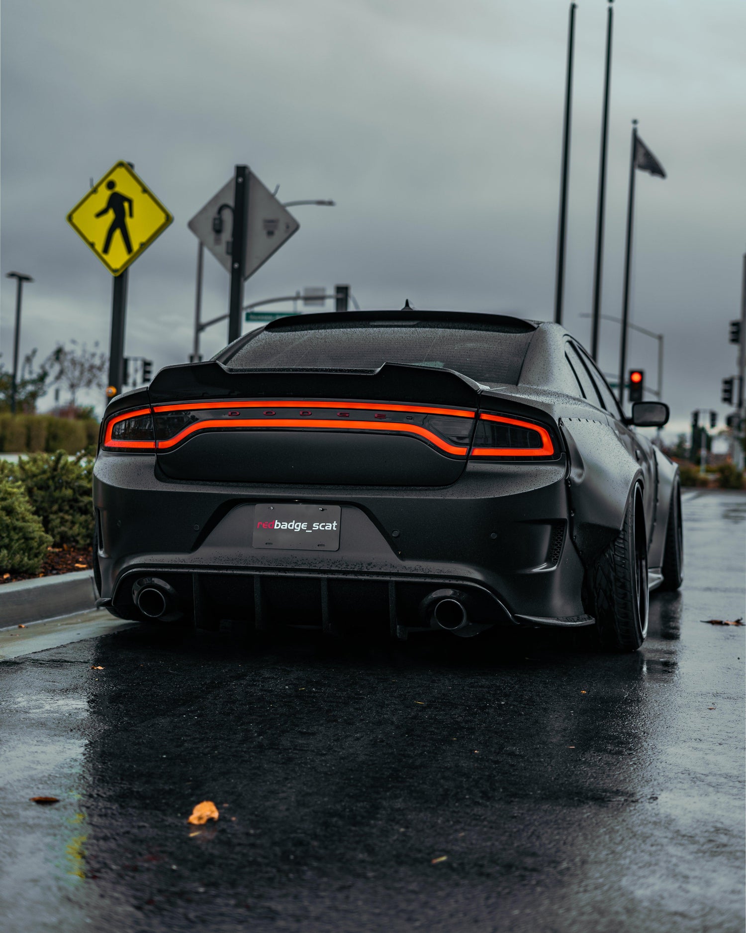 Rear view of black Dodge Charger equipped with Dodge Charger LD widebody kit SHIROKAI on wet road