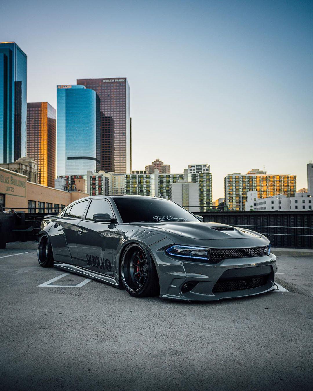 Gray Dodge Charger with Dodge Charger LD widebody kit SHIROKAI parked in urban setting with city skyline
