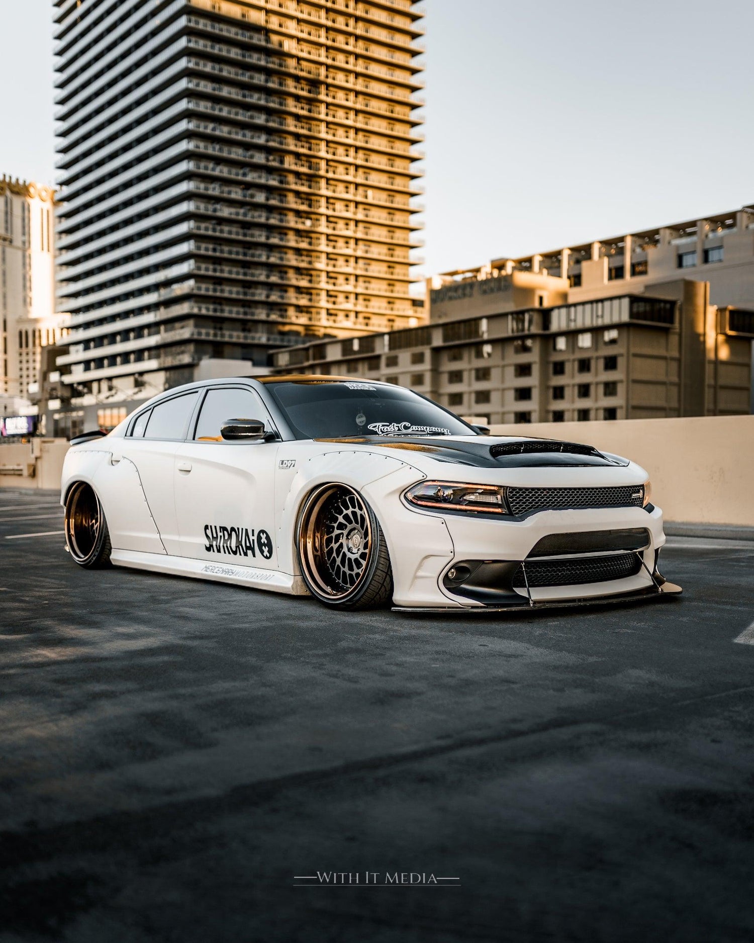 White Dodge Charger featuring a widebody kit SHIROKAI with custom rims in an urban setting