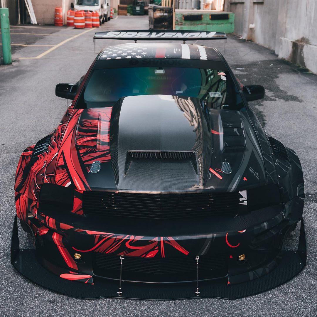 Front view of a black and red Ford Mustang with ford mustang S197 widebody kit SHIROKAI installed on a street