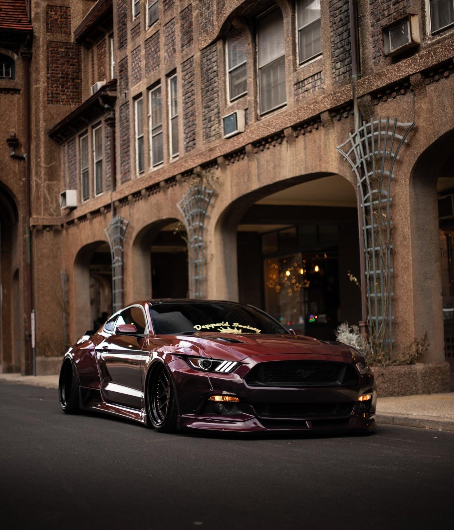 Maroon Ford Mustang S550 with Ford Mustang S550 widebody kit SHIROKAI in an urban setting