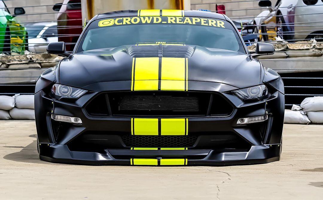 Black Ford Mustang with yellow racing stripes featuring Ford Mustang S550 widebody kit SHIROKAI front view