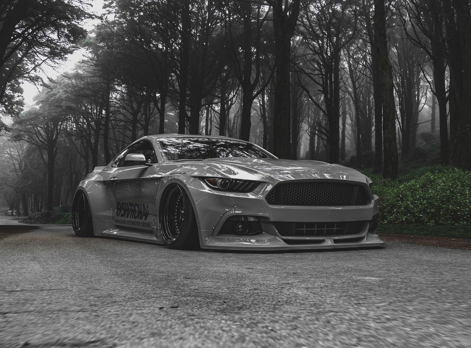 Silver Ford Mustang S550 with SHIROKAI widebody kit parked on forest road in black and white photo