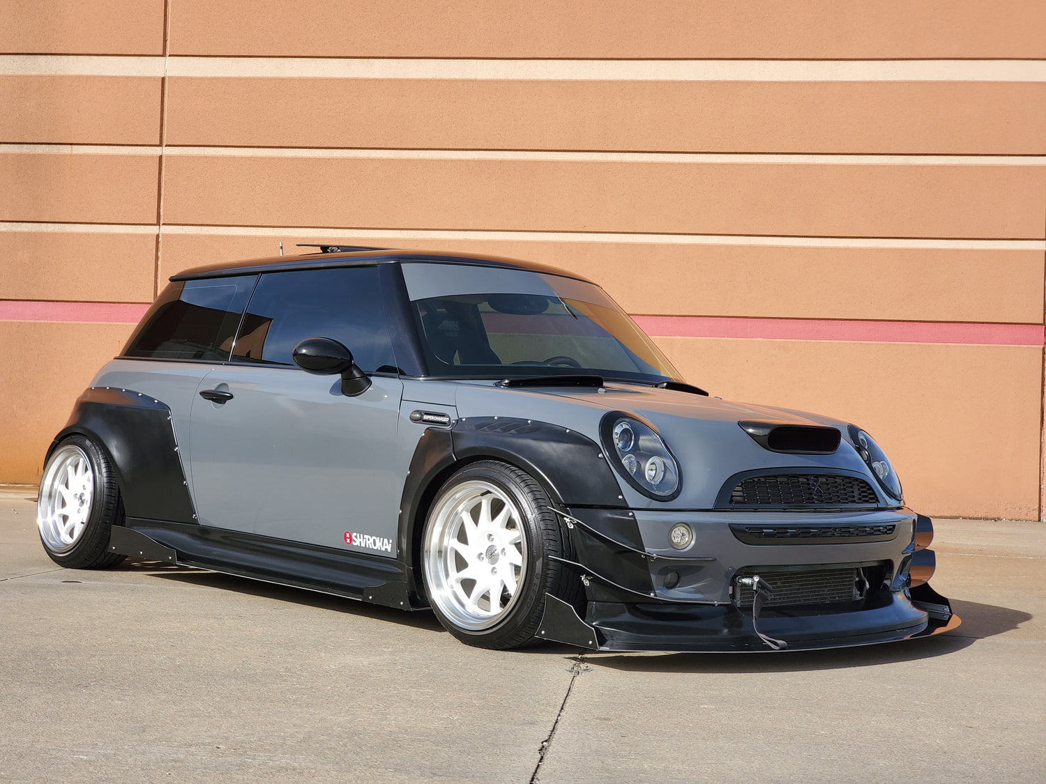 Mini Cooper S R53 with black and gray widebody kit SHIROKAI and white wheels parked outdoors