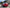 Red Mini Cooper S R53 with widebody kit SHIROKAI installed parked outdoors with black wheels